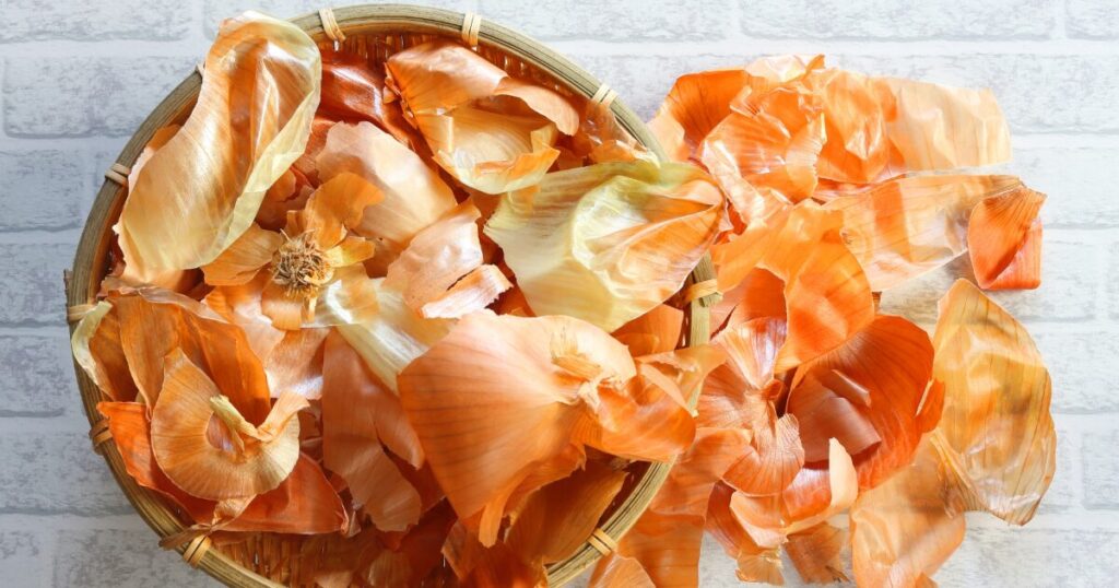 ざるに集められた玉ねぎの皮の食品廃棄物