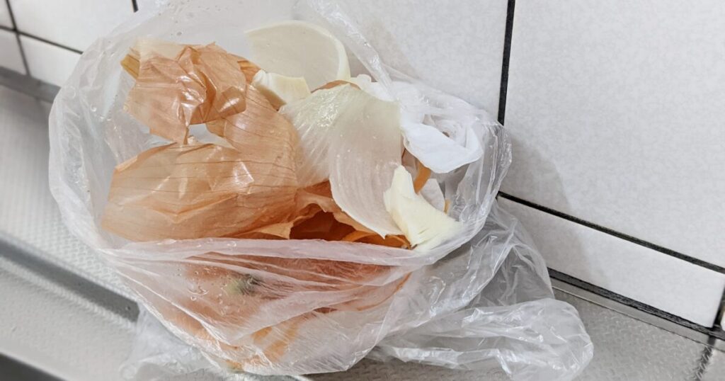 ビニール袋に集められた玉ねぎの皮の食品廃棄物